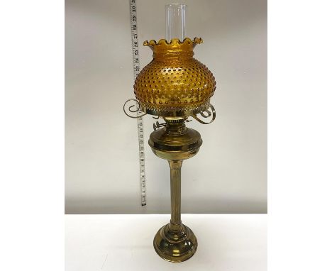 A antique brass based oil lamp with amber glass shade h70cm, shipping unavailable 