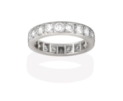 A Diamond Eternity Ring, the twenty round brilliant cut diamonds in white claw and channel settings, total estimated diamond 