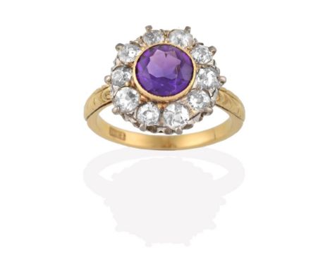 An Amethyst and Diamond Cluster Ring, the round cut amethyst in a yellow rubbed over setting, within a border of old cut diam