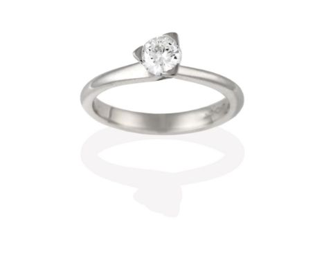 A Platinum Diamond Solitaire Ring, the round brilliant cut diamond in a claw setting, to asymmetrical shoulders on a plain po