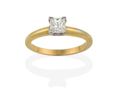 An 18 Carat Gold Diamond Solitaire Ring, the princess cut diamond in a white four claw setting, to a yellow tapered shoulder 
