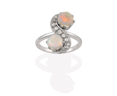 An Opal and Diamond Ring, the S-shaped twist composed of old cut diamonds terminating to round cabochon opals, in white claw 