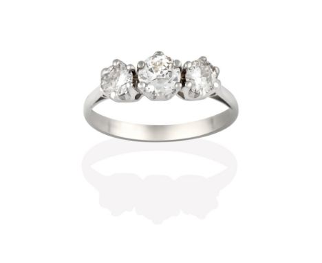 A Diamond Three Stone Ring, the round brilliant cut diamonds in white claw settings, to a tapered shoulder plain polished sha