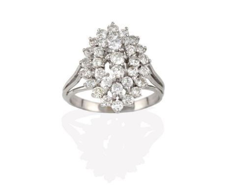 A Diamond Cluster Ring, three round brilliant cut diamonds within a double stepped border of round brilliant cut diamonds, in