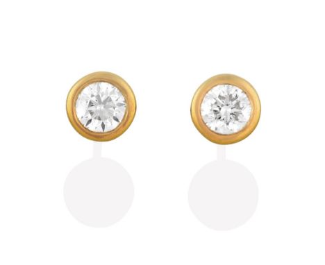 A Pair of Diamond Solitaire Earrings, the round brilliant cut diamonds in yellow rubbed over settings, total estimated diamon