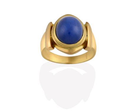 A Synthetic Star Sapphire Ring, the oval cabochon synthetic star sapphire in a yellow rubbed over setting, to a tapered shoul