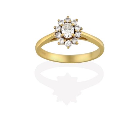 An 18 Carat Gold Diamond Cluster Ring, the central oval cut diamond within a border of round brilliant cut diamonds, in yello