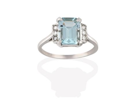 An Aquamarine and Diamond Ring, the emerald-cut aquamarine in a white claw setting, flanked by trios of eight-cut diamonds in