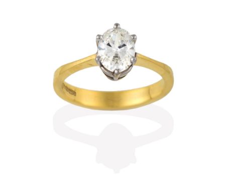 A Diamond Solitaire Ring, the oval cut diamond in a white claw setting, to a yellow tapered shoulder plain polished shank, es