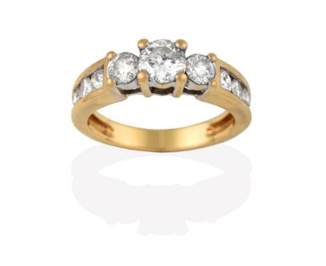 A Diamond Three Stone Ring, the graduated round brilliant cut diamonds in yellow claw settings, to a graduated round brillian