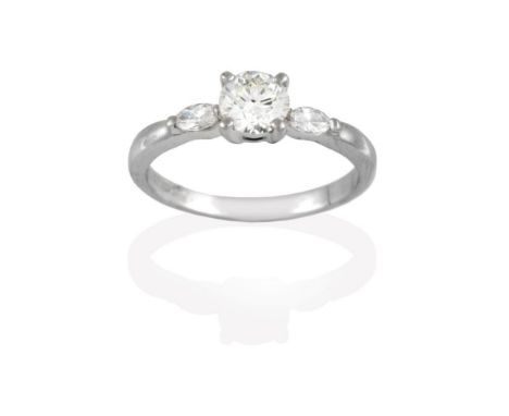 A Platinum Diamond Solitaire Ring, the round brilliant cut diamond in a claw setting, to marquise cut diamond set shoulder pl