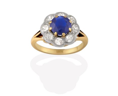 A Sapphire and Diamond Cluster Ring, the round cut sapphire in yellow claw settings, within a border of old cut diamonds in w