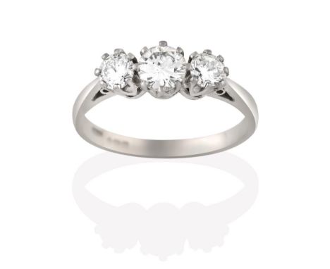 An 18 Carat White Gold Diamond Three Stone Ring, the graduated round brilliant cut diamonds, in claw settings, to a tapered s