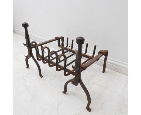 A 20th century blacksmith-made iron dog-grate and a pair of iron firedogs with iron rests and helmet-form finials (44 cm high