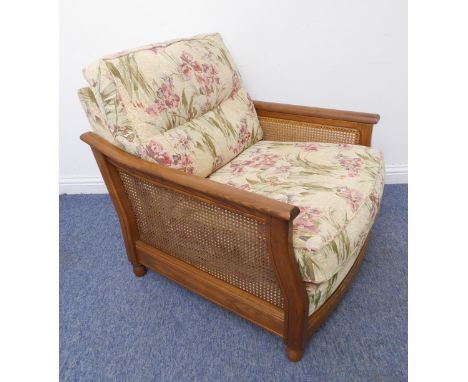 A matching Ercol single armchair (matches lots 453 and 455): rich coloured elm and rattan-caned sides; upholstered lily patte