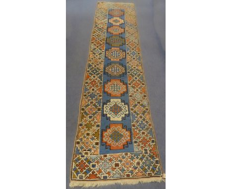 A mid-20th century Yumseh (Turkish) carpet runner, the ivory ground decorated with red, blue and pink geometric motifs. (69 x