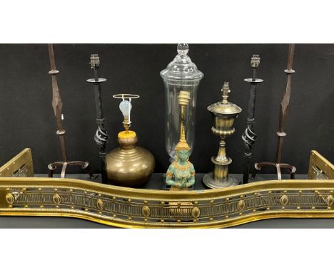 A pair of wrought iron standing candle holders, 77cm high, another similar; hurricane lamp; brass fire fender, 140cm wide; et