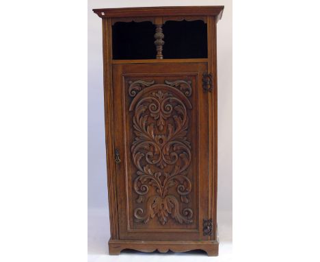 A late Victorian/Edwardian carved oak tall cupboard, c.1900The moulded cornice above canopied recess with central uprights, a