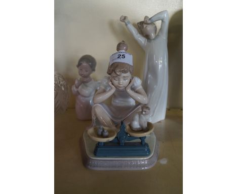 Three Lladro ceramic figures, the first modelled in the form of a girl seated weighing her kitten on scales, height of larges