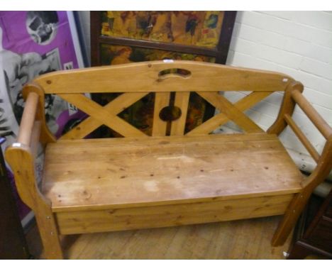 A modern pine two seater bench with pierced back 