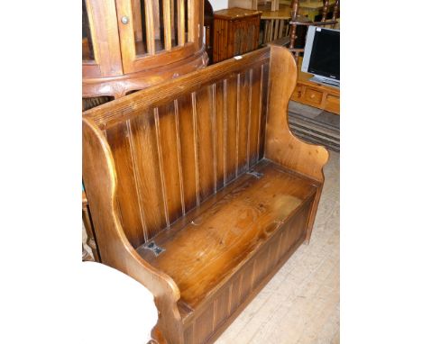 A good quality reproduction solid oak bench with panelled back and the hinged seat lifts to enclose storage compartment 