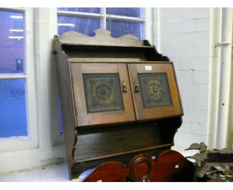 An Aesthetic period hanging shelf unit the twin doors having gilt decorated stylised symbols  