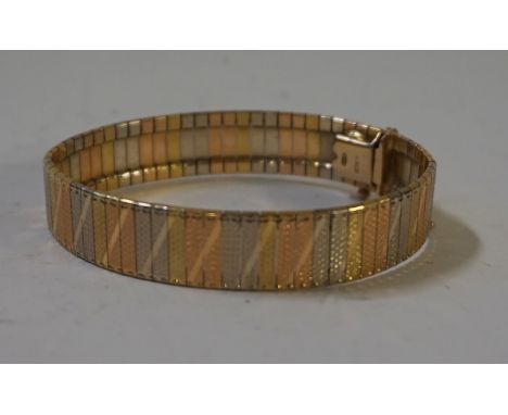 An 18ct tri coloured gold cuff bracelet with engine turned and diagonal detail, stamped 750, approx 29gms.