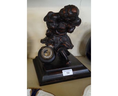 An early 20th century carved wooden sculptural barometerModelled in the form of a hunchback beside a circular aneroid baromet