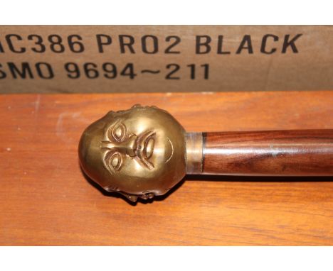 A walking stick, having a four sided figure decorated handle (63)