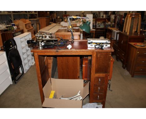 A Neslein watch maker's table having an arrangement of ten drawers with various fitted accessories; to include a lamp etc. an