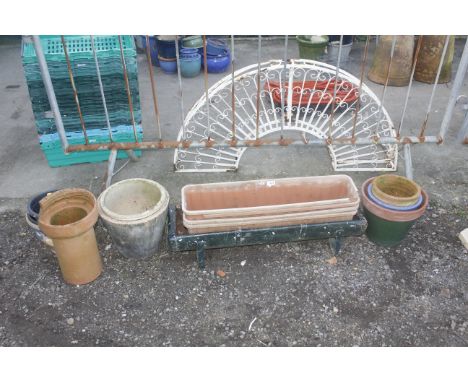 A collection of plant pots and rectangular planters together with a metal feed trough