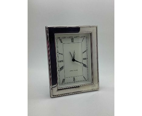A Modern Hallmarked Silver Mounted Rectangular Mantel Clock, within ribbon and reed border, on wooden back, overall height 16
