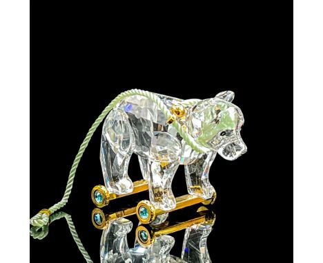 Clear faceted crystal fun figure of a bear on golden casters. A light blue cord is around the neck. Swarovski mark. Item numb