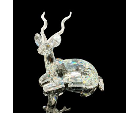 Brilliant cut crystal figure of a kudu, a type of antelope, lying down resting, with satin horns. Swarovski etched mark. This