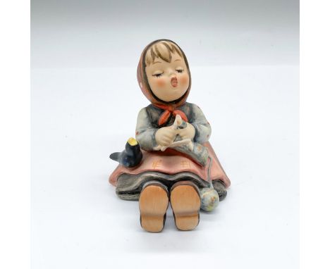 Hand painted figure of a seated girl knitting while she is singing. Goebel backstamp. Issued: 20th centuryDimensions: 3.5"L x