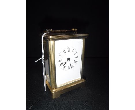 A BRASS-CASED CARRIAGE CLOCK with white enamel dial