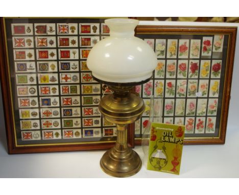 Cigarette Cards - A brass oil lamp; a book, Discovering Oil Lamps; a framed set of cigarette cards, regimental standards and 