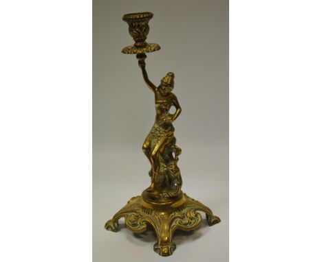 A 19th century candlestick in the form of a scantily clad caryatid in the Etruscan taste raised on a scrolling base 