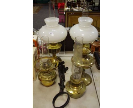 A Miller and Son wall mounted brass oil lamp; Two Aladdin 23 oil lamps; two others