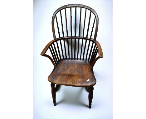 A 19th century Windsor stick back armchair in elm