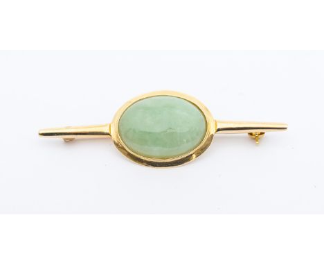 A 14ct gold and nephrite jade brooch, set with an oval cabochon jade, to a bar brooch, length approx 50mm, stamped 14k, total