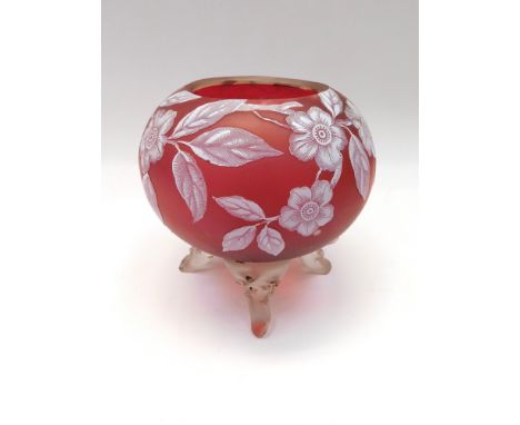 A Stourbridge style ruby cameo glass globe shaped vase, the entire decorated with hedge roses, on four moulded clear glass sc