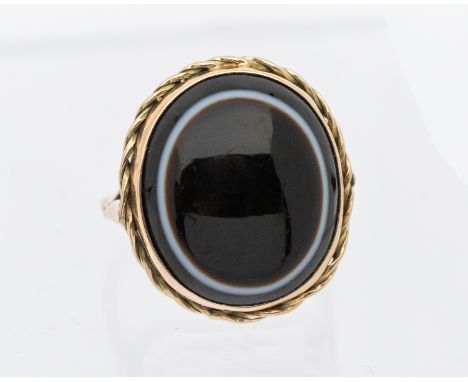 A Victorian 9ct gold bulls eye agate set ring, the stone measuring approx 18 x 15mm, rope edge gold border, size L1/2, total 