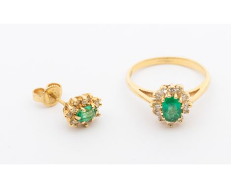 A diamond and emerald cluster 14ct gold cluster ring, comprising an oval mixed cut emerald within a diamond set surround, set