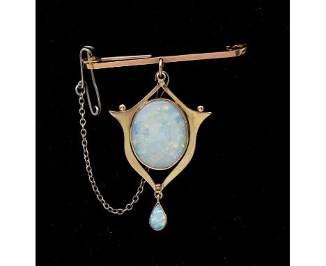 An early 20th century opal and 9ct gold brooch, comprising a large white oval opal approx 16x12mm, within a fancy gold border