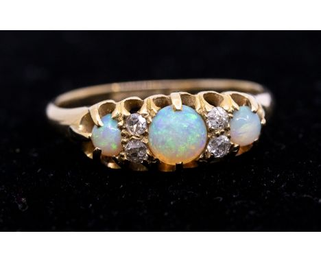 An opal and diamond 18ct gold ring, set with round opals with small diamond accents, width approx 7mm, size O, total gross we