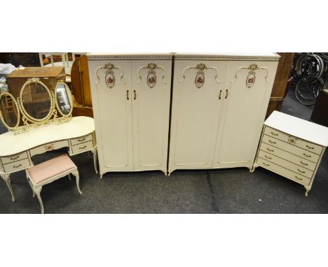 A mid 20th century French bedroom suite including two wardrobes, a dressing table,stool and chest of drawers with decorative 