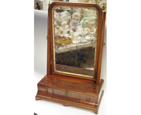 A George III mahogany dressing table mirror, surmounted with brass urnular finials, foxed looking glass above three curved dr