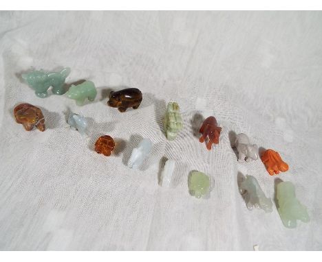 A collection of fifteen miniature hand carved netsukes .depicting animals to include jade, amber, natural stone, tigers eye a