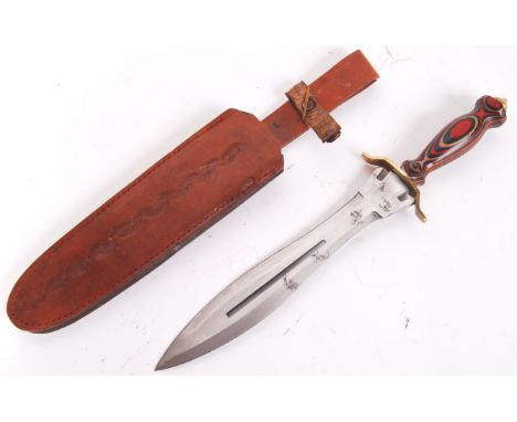 A 20th century African style large hunting knife, with muticoloured decorative handle, with brass top. Within its original le
